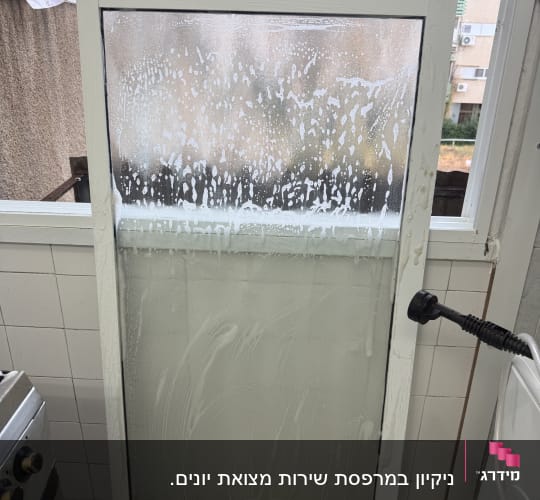 חלון עם סבון בתהליך ניקוי במטבח